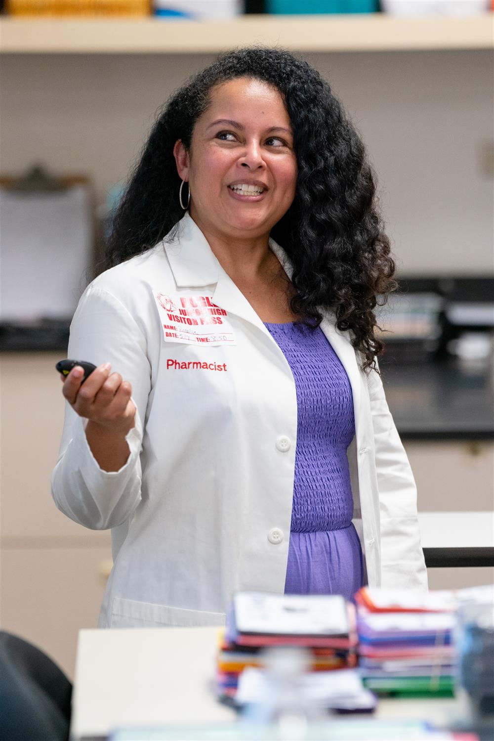 A close-up angle of a pharmacist speaking to a classroom of eighth graders.